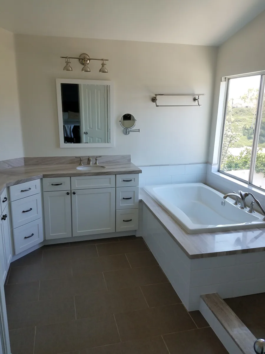 Primary bathroom with soaking tub and white vanity