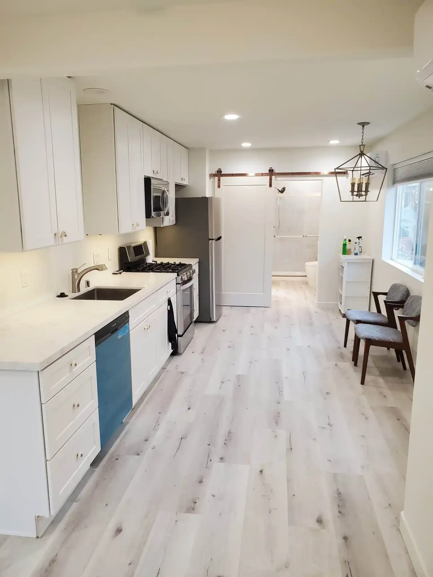 Completed Ward ADU interior in Murrieta, CA with white kitchen and barn door bathroom