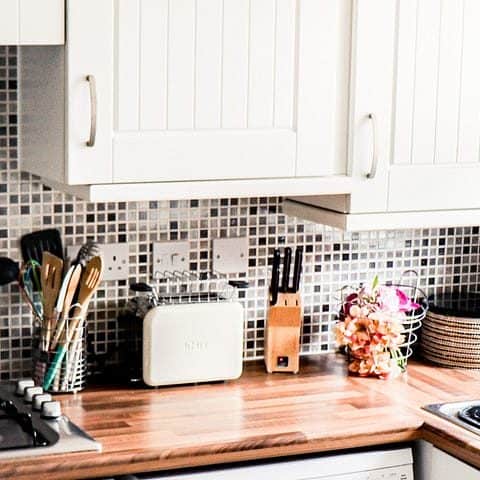 Compact ADU kitchen with white cabinets and open shelving in Temecula, CA